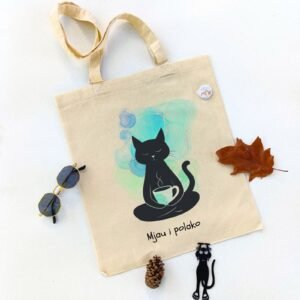 Ceger Mjau i Polako sa ilustracijom crne mačke koja meditira i drži šolju kafe ili čaja. Savršen poklon za ljubitelje mačaka i trenutaka mira.