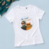 Bela ženska majica Be Cool, Be Mjau sa ilustracijom žene i narandžaste mačke sa sunčanim naočarima na pastelno plavoj pozadini.