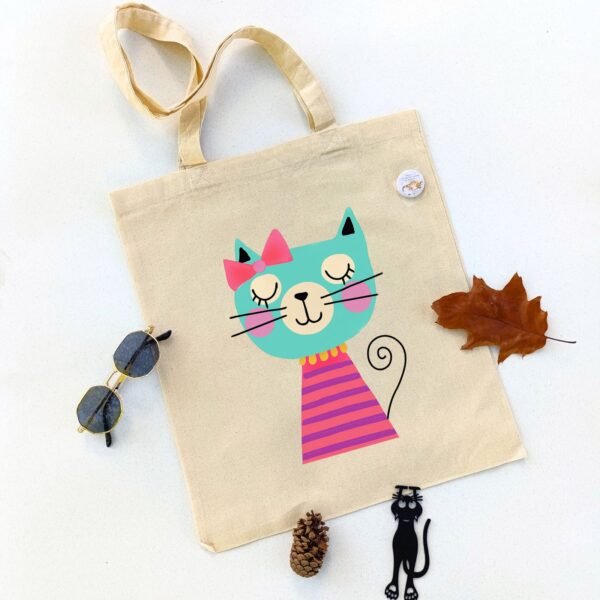 Ceger Maca spavalica sa ilustracijom uspavane tirkizne mačke sa rozom mašnom i šarenom majicom. Originalan poklon za ljubitelje mačaka.