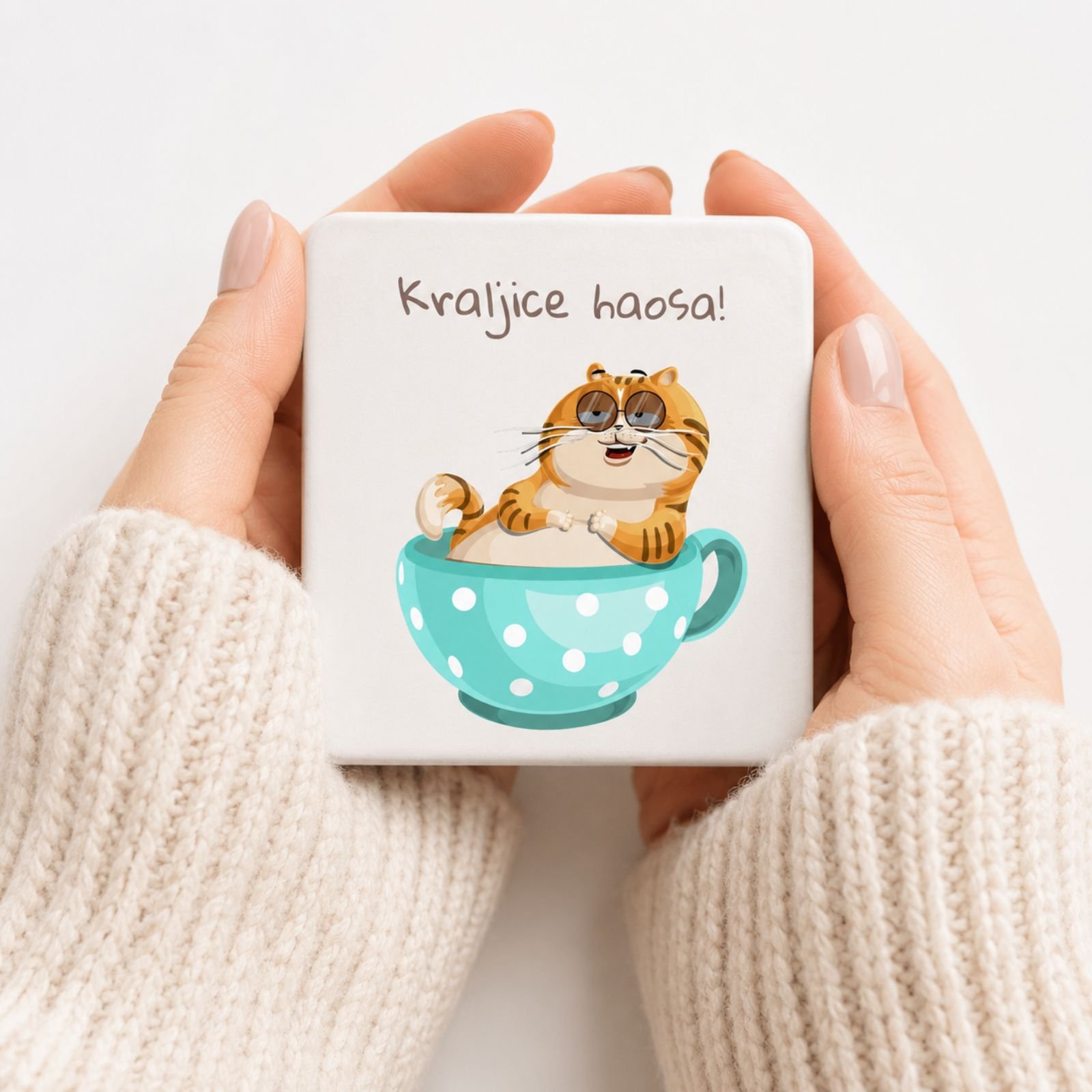 Žena drži magnet Kraljice haosa sa mačkom – originalan poklon za drugaricu