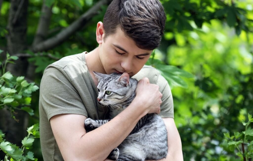 Mačka vas ne bira slučajno - Mačka grli svog vlasnika preko ramena, pokazuje bliskost i poverenje.