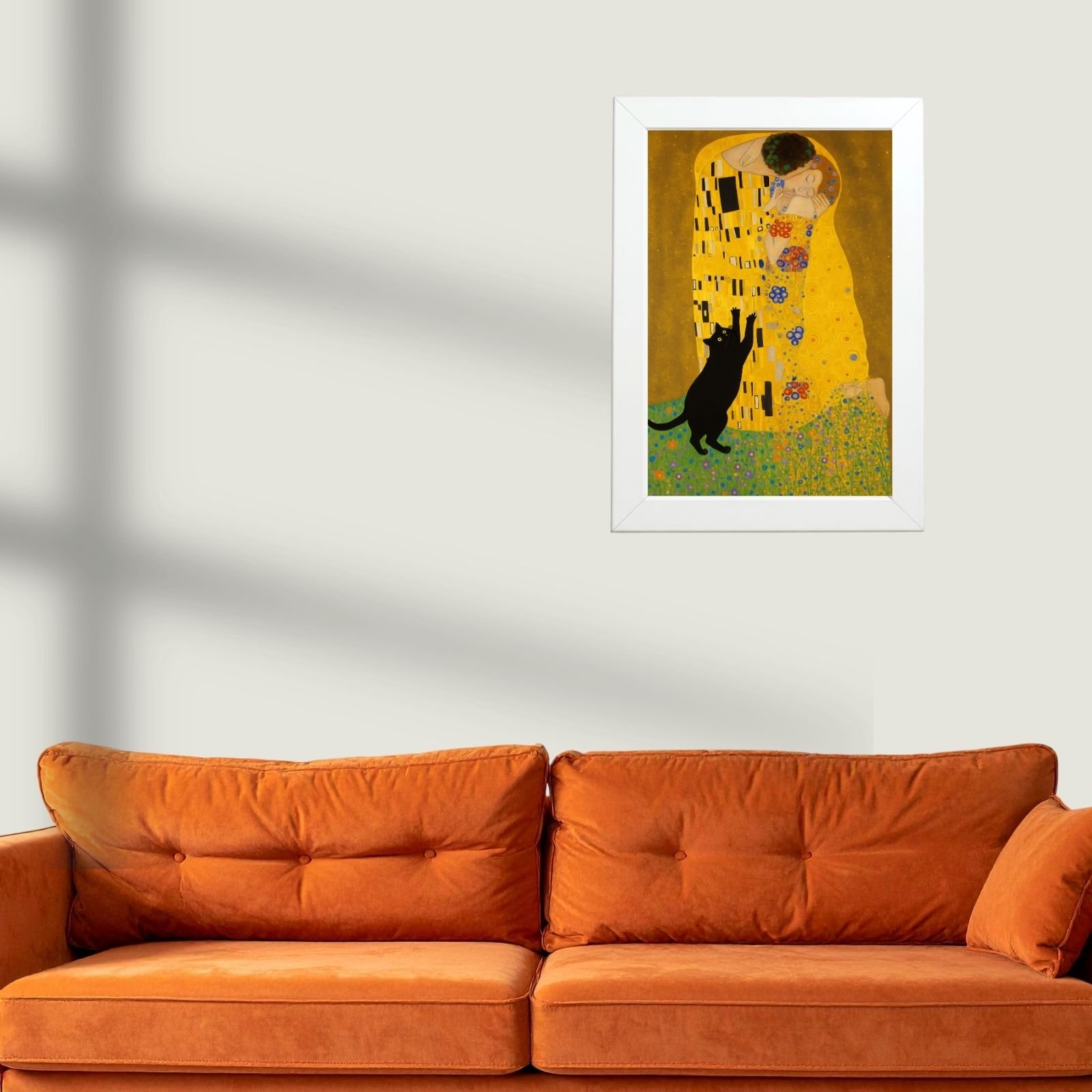 Mačiji poljubac poster iznad narandžaste garniture u dnevnoj sobi